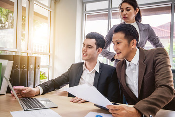 Happy business team celebrate success looking at laptop in the office. Successful, winners excited...