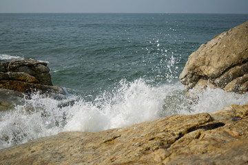 Strong waves breaking on the shore with sea foam