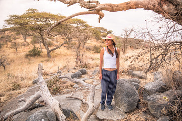 Girl at view point looking to the bush savannah of Serengeti at sunset, Tanzania - Safari in Africa