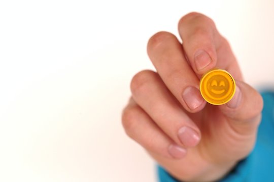 Positive emotion. OK.Positive  feedback. Yellow smiley in a man's hand .REVIEW