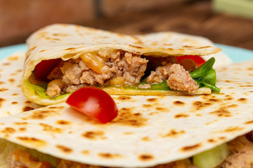 fajitos with minced meat vegetables in a corn tortilla on a blue plate dark wooden background. fast food traditional food concept