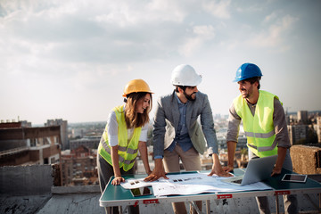 Team of architects people in group on construciton site check documents and business workflow.