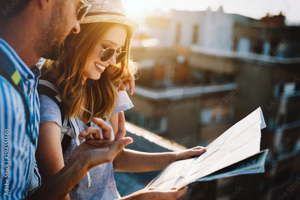 Wall mural multiethnic traveler couple using map together on sunny day