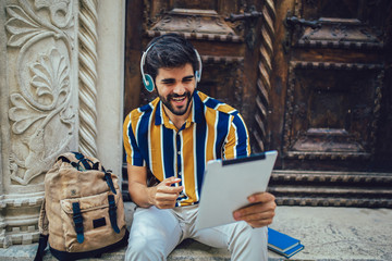 Young handsome tourist men using digital tablet in a city.