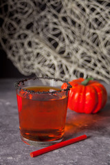 Glass with pumpkin cocktail with autumn leaves and pumpkins on the background