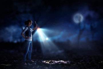 Obraz premium Young woman holding a flashlight