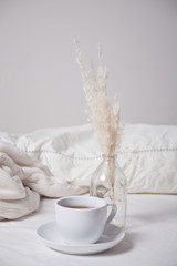 Close up of cup of tea, milk and bouquet of white flowers