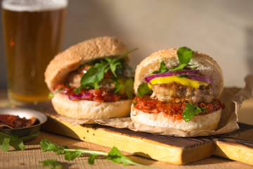 Burger flyer. Cheese burger with grilled meat, cheese, salad and onion rings. Close-up of delicious fresh home made burger on concrete brick background