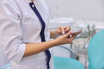 Obraz na płótnie Canvas Close up of female doctors hand with mobile phone smartphone