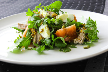 Warm salad with tuna, arugula, tomatoes, egg. Idea and recipe for healthy lunch or dinner