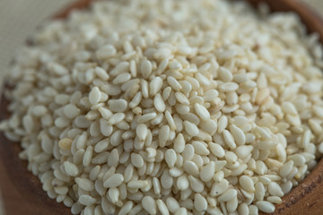 scoop of healthy sesame seeds on sesame seeds background