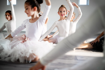 Fototapeta na wymiar Group of fit happy children exercising ballet in studio together