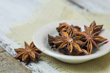 Heap of anise stars, isolated on wooden background