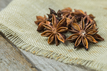 Heap of anise stars, isolated on wooden background