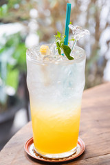 Summer drink; fresh citrus and lime with honey juice on ice in glass; shot through window glass.