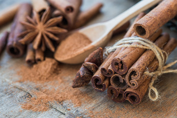 Heap of cinnamon sticks and ground cinnamon with dust effect. Aromatic spice.