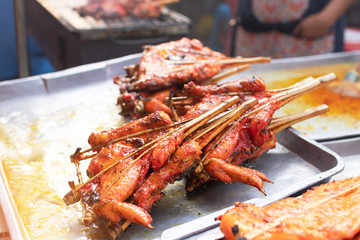 Grilled chicken marinated with curcuma on tray, ready to eat; Thai street food market. 