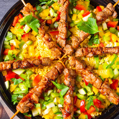 Lamb skewers with curry rice and different vegetables