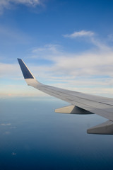 Flying high, wing of an airplane flying above the clouds