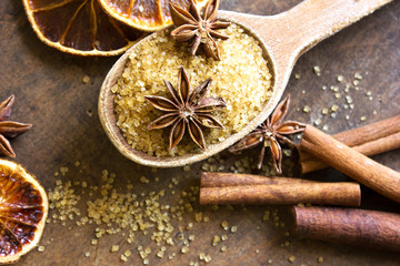 Spices and herbs. Christmas holiday composition : Beautiful close-up of dry Oranges, Cinnamon sticks and star Anis. Cinnamon sticks, anise stars,  brown  sugar  on textured background