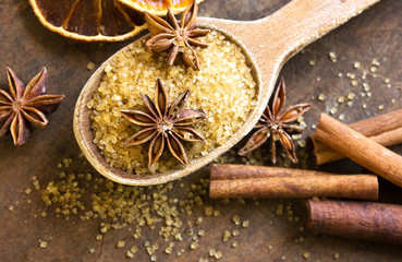 Spices and herbs. Christmas holiday composition : Beautiful close-up of dry Oranges, Cinnamon sticks and star Anis. Cinnamon sticks, anise stars,  brown  sugar  on textured background