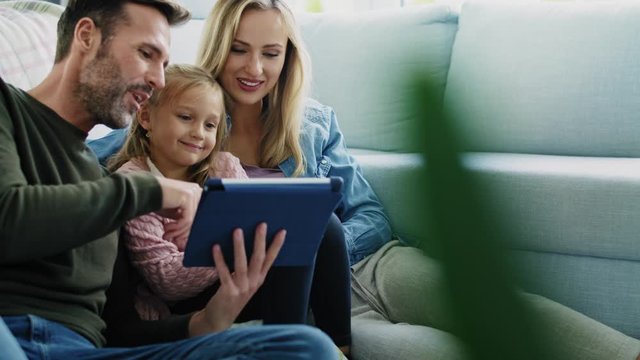 Family with tablet spending time together in living room