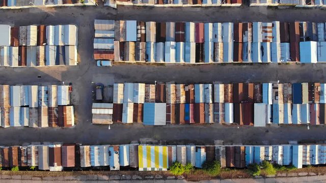 Garage in the city. Roofs of the garages are arranged in even rows close to each other. Top view, panorama from left to right.Top view of the garage at sunset. Drone aerial footage.