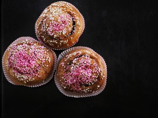 Swedish cinnamon buns (kanelbullar) on dark background with copy space.