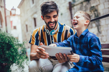 Portrait of man with son using digital tablet
