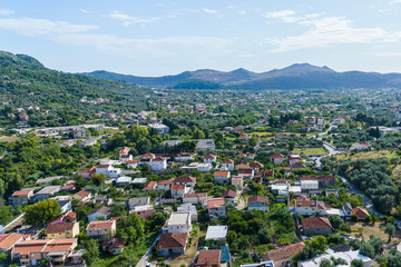 Fototapeta premium tiled roofs and greenery against the backdrop of the mountains