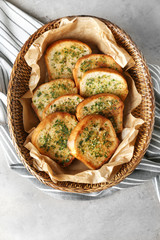 Slices of toasted bread with garlic and herbs on grey table, top view