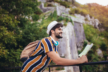 Handsome bearded tourist with backpack is making travel across city.