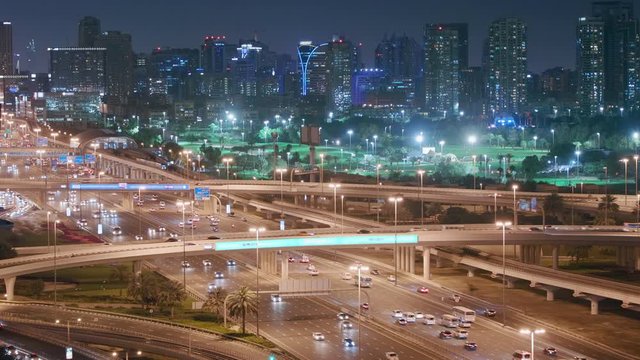 Dubai Golf Course with a cityscape of Gereens and tecom districts at the background aerial night view. Traffic on sheikh zayed road with junction