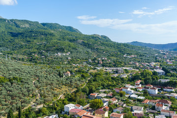 Obraz premium tiled roofs and greenery against the backdrop of the mountains