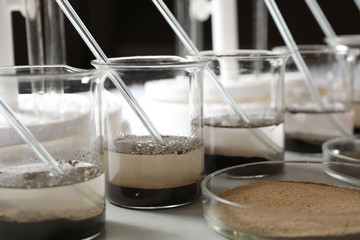 Glassware with soil samples and extracts on light table. Laboratory research