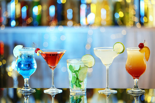Glasses of fresh alcoholic cocktails on bar counter - Powered by Adobe