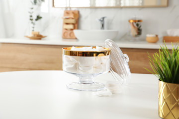 Jar with cotton pads on table in bathroom
