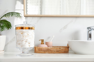 Jar with cotton pads on bathroom countertop