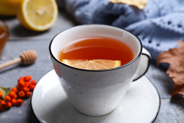 Cup of hot drink on grey wooden table, closeup. Cozy autumn atmosphere