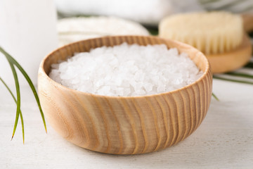 Fototapeta na wymiar White sea salt for spa scrubbing procedure on wooden table