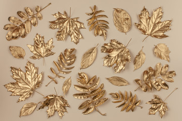 Autumn golden leaves pattern on beige background. Flat lay, top view.
