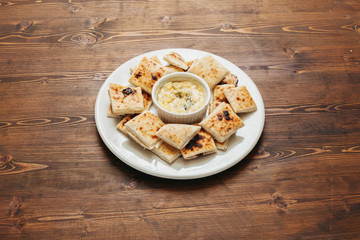 Pita bread with dip on a wooden table