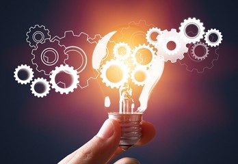 Hand holding light bulb and cog inside. Idea and imagination. Creative and inspiration. Innovation...