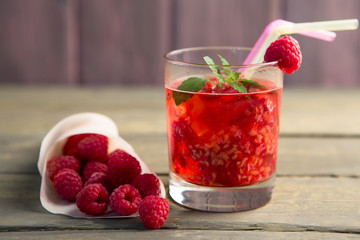 Glass of fresh strawberry smoothie and fresh strawberries on pink wooden background. Healthy food and drink concept.