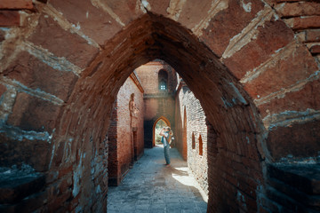 Fototapeta premium woman traveller with backpack enjoying view looking at Buddhist ancient temple in Bagan, Myanmar.