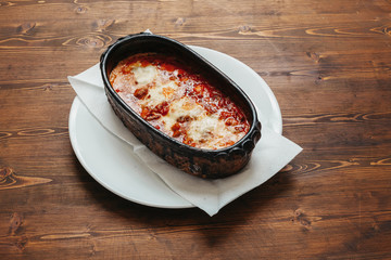 Italian baked lasagna on wooden table