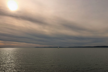 Stunning autumn landscape of lake Balaton. Vibrant sky in cloudy day. Sun reflected in water. ...