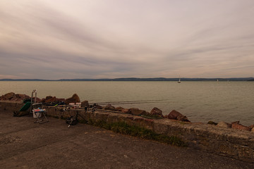 Avid fisherman fishing spot. Fishing tackle on a pier on the background of the lake Balaton....