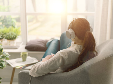Woman Relaxing On The Couch And Listening To Music
