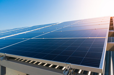 Solar panels and blue sky background.Solar cells farm on the roof.Photovoltaic modules for renewable energy.Save the earth and the energy with good environment concept.